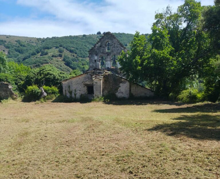 Zona desbrozada junto a una construcción de piedra en un entorno rural de Valdueza.