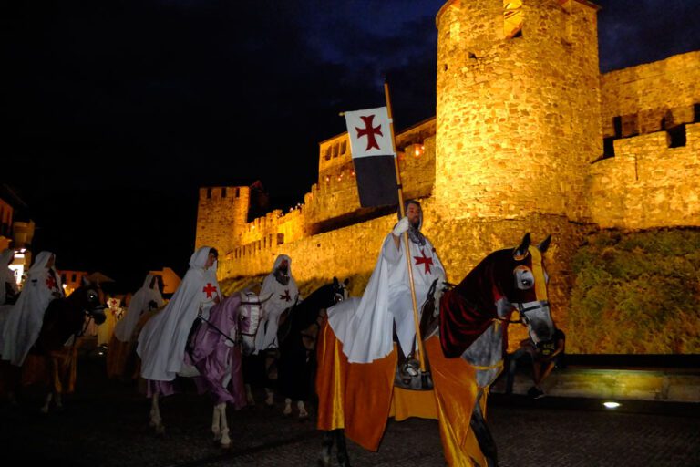 Desfile de caballeros templarios a caballo junto al Castillo de los Templarios de Ponferrada durante la Noche Templaria.