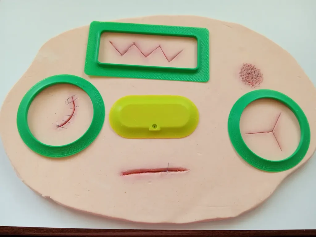 Prototipo de apósito 3D sobre una superficie de simulación de piel con diferentes tipos de heridas.