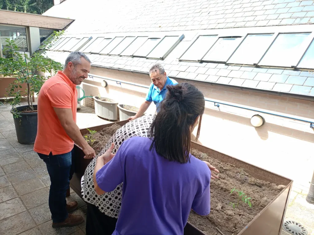David Pacios supervisa una mesa de cultivo instalada en el Centro de Día del Plantío junto a usuarios y personal del centro