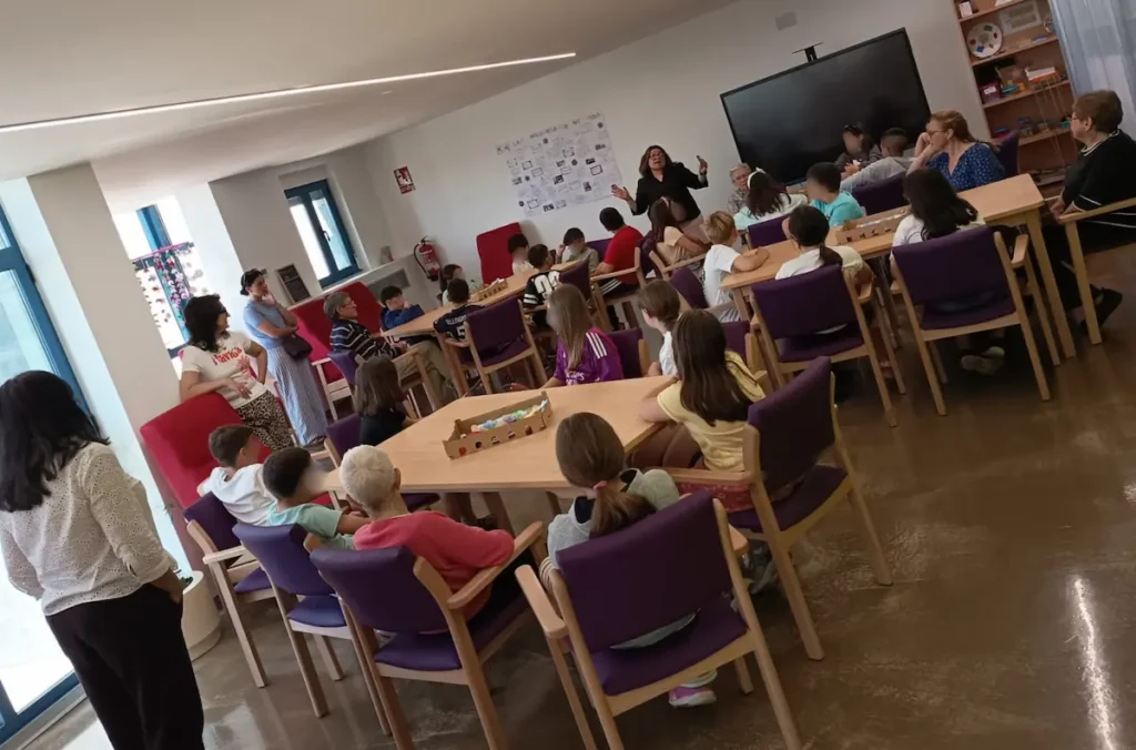 Alumnos del CEIP San Ildefonso y usuarios del Centro de Día de Camponaraya participan en un encuentro intergeneracional con actividades compartidas.