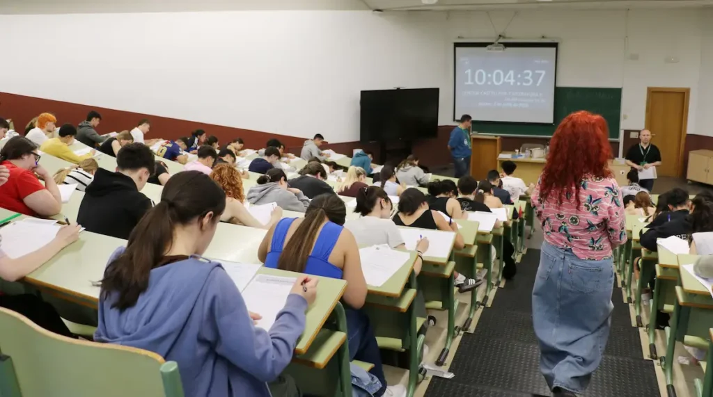 Estudiantes realizando un examen de la PAU en un aula universitaria bajo la supervisión del profesorado.
