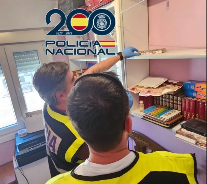 Agentes de la Policía Nacional inspeccionan una estantería en una vivienda de Ponferrada tras el hallazgo de un antiguo cartucho de dinamita