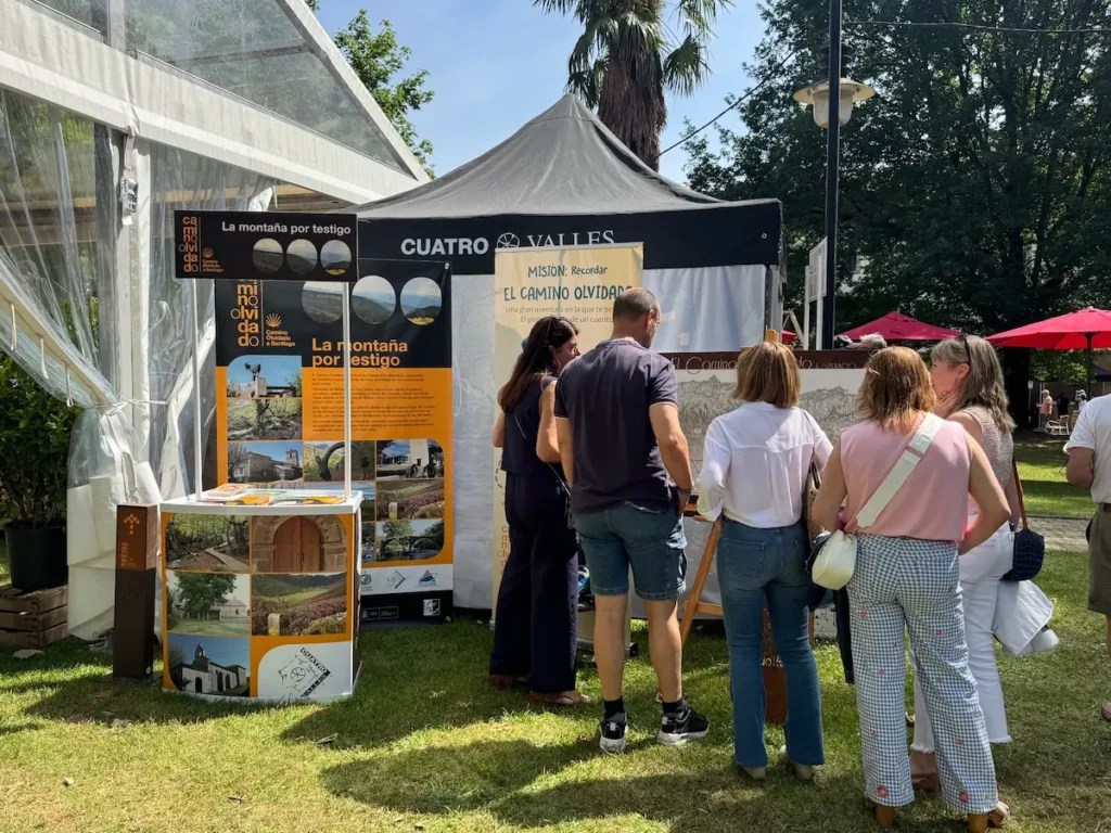 Visitantes consultan material promocional del Camino Olvidado a Santiago en el stand de Cuatro Valles durante el Enkarterri Fest de Zalla