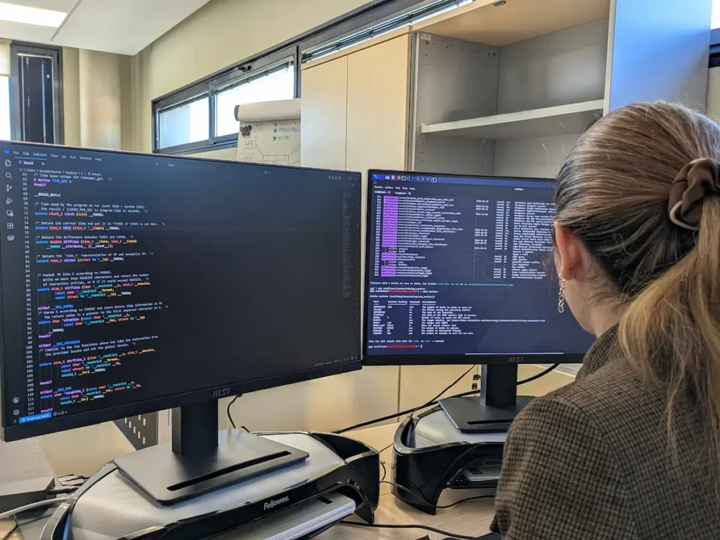 Profesional trabajando con dos monitores durante un ejercicio de ciberseguridad industrial en el laboratorio de CIUDEN en Cubillos del Sil.