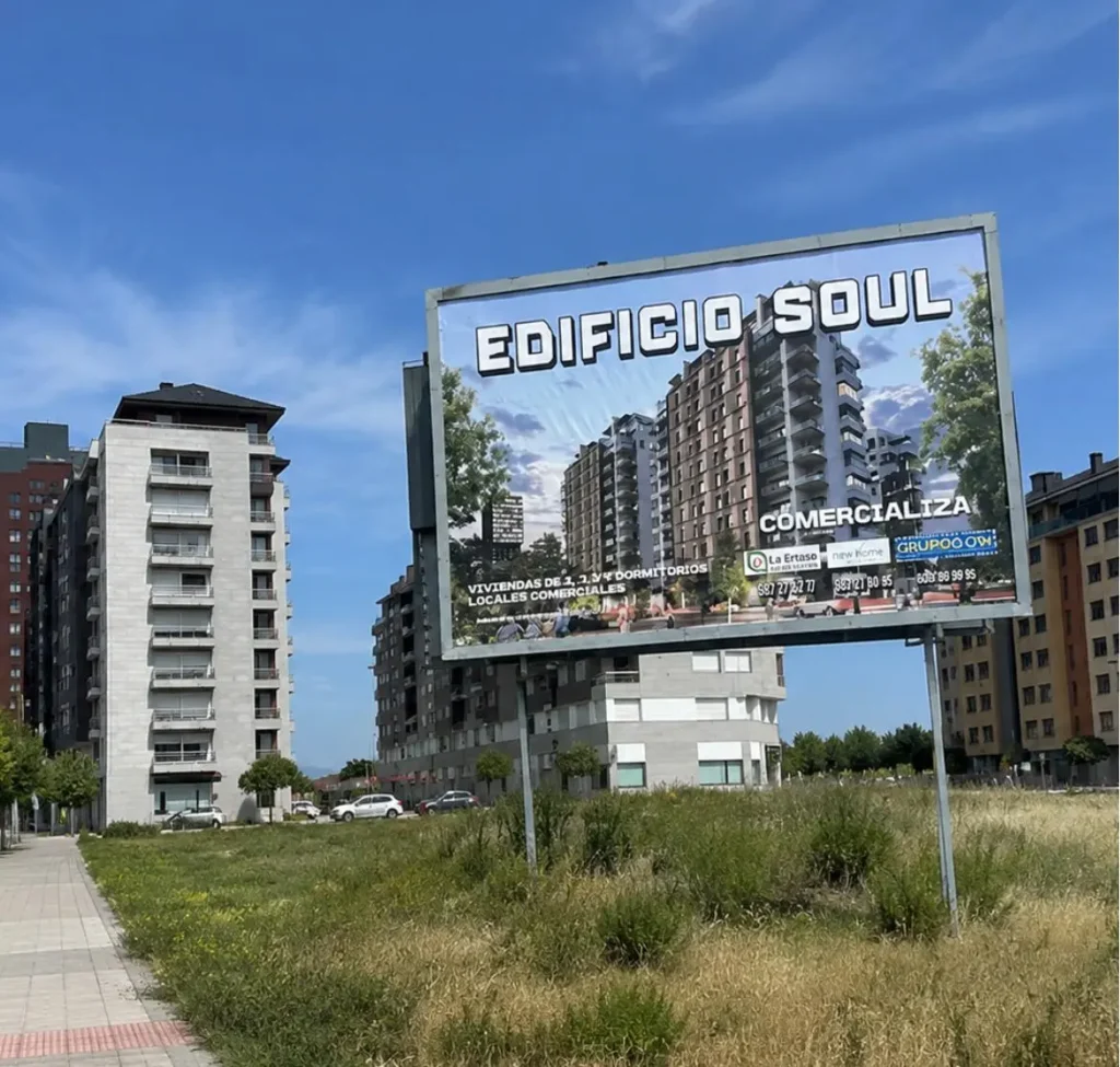 Cartel publicitario del Edificio Soul en el barrio de La Rosaleda de Ponferrada, con bloques de viviendas de la ciudad