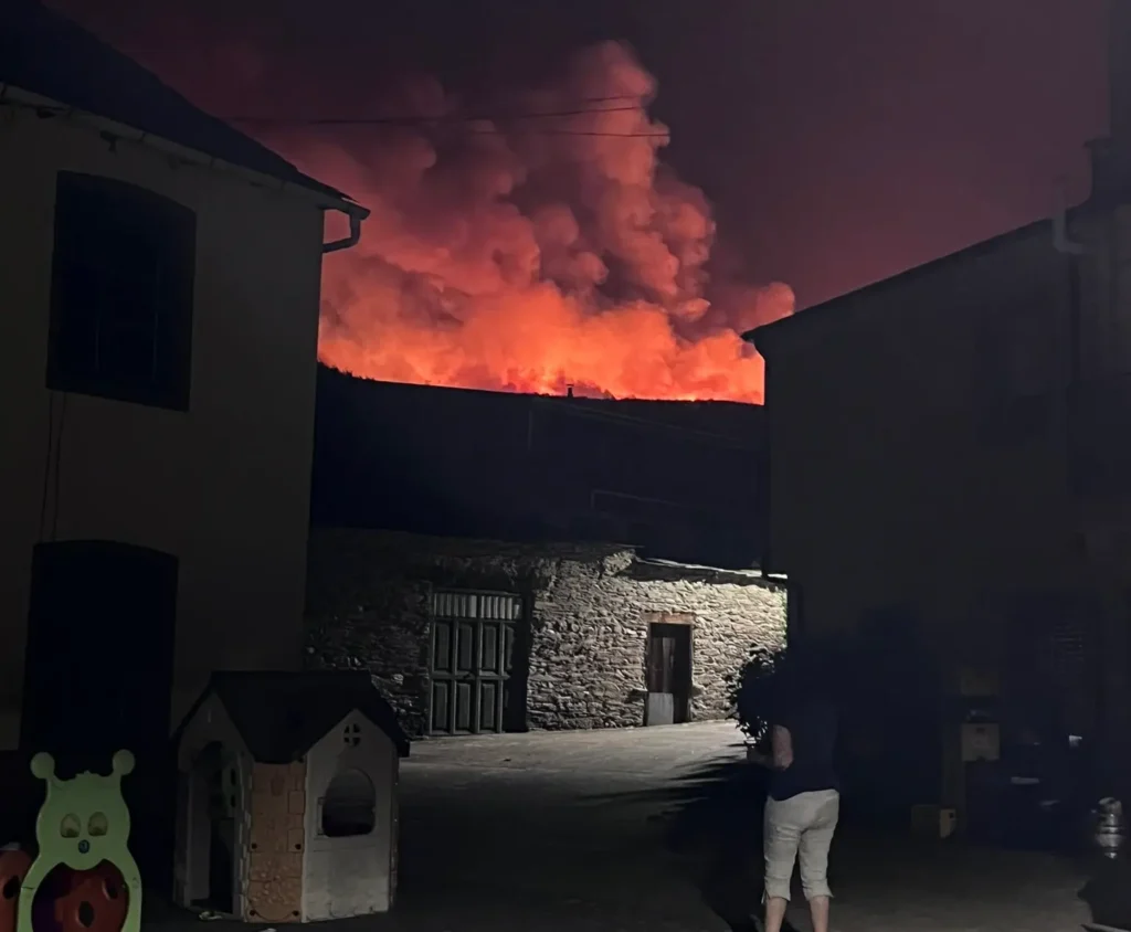 El incendio de Cobrana desde la localidad de Congosto, con una mujer mirando la virulencia de las llamas
