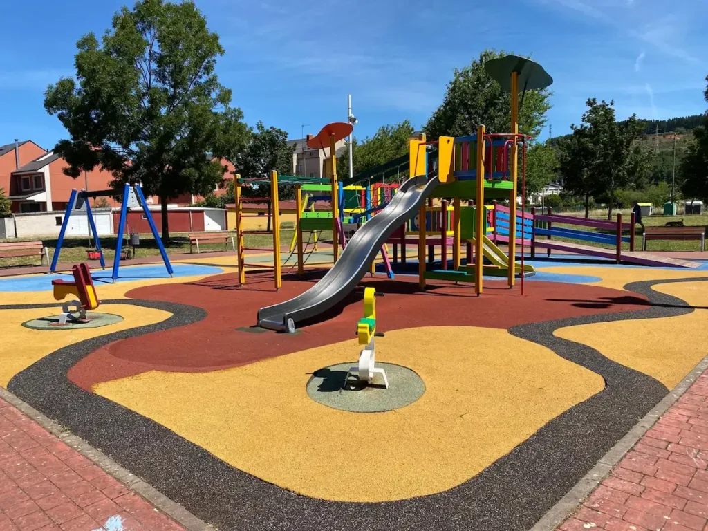 Parque infantil renovado en el barrio de Compostilla, en Ponferrada, con nuevos juegos y suelo de caucho de colores.