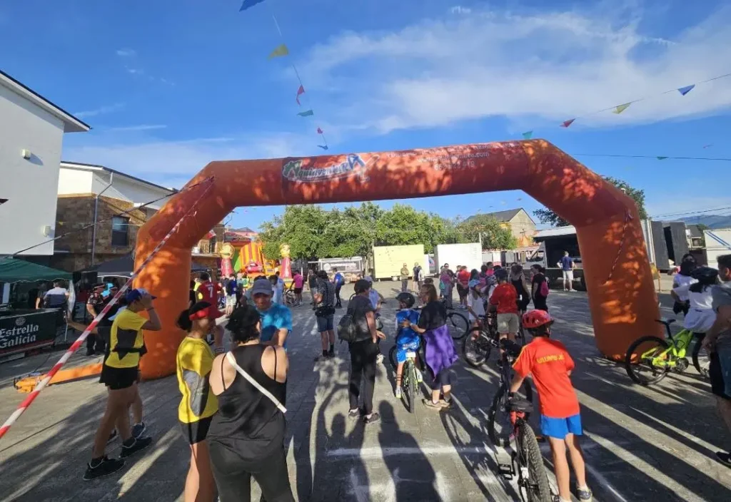 Participantes de la Ruta de la Fruta de Carracedelo junto al arco de salida en una jornada deportiva y familiar.