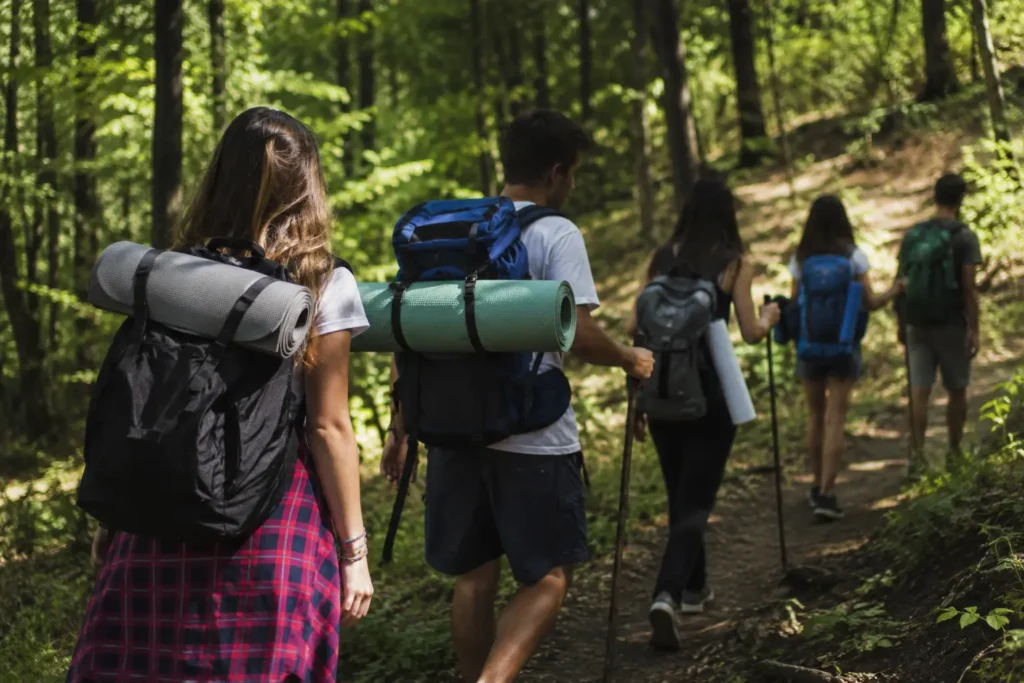 Grupo de jóvenes realizando una actividad de senderismo al aire libre en un entorno forestal