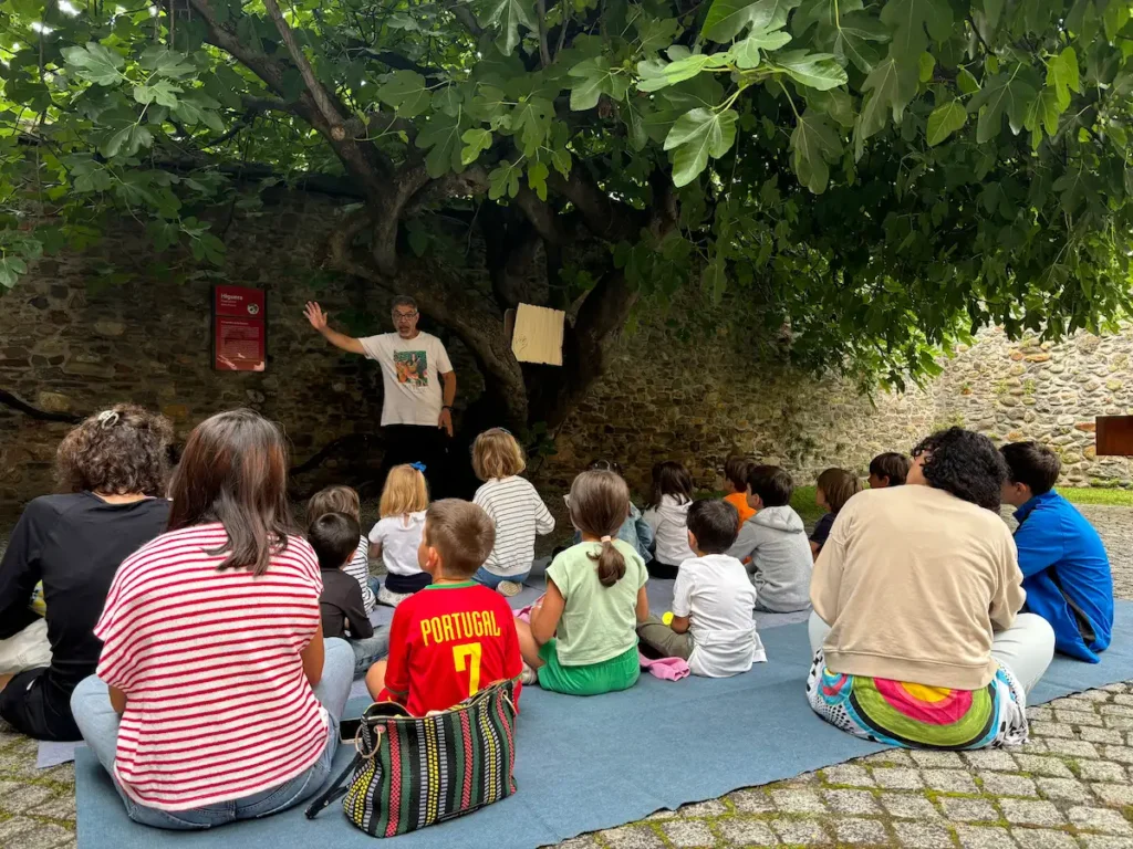 Niños y familias participan en una actividad de cuentacuentos bajo la higuera del patio del Museo del Bierzo.