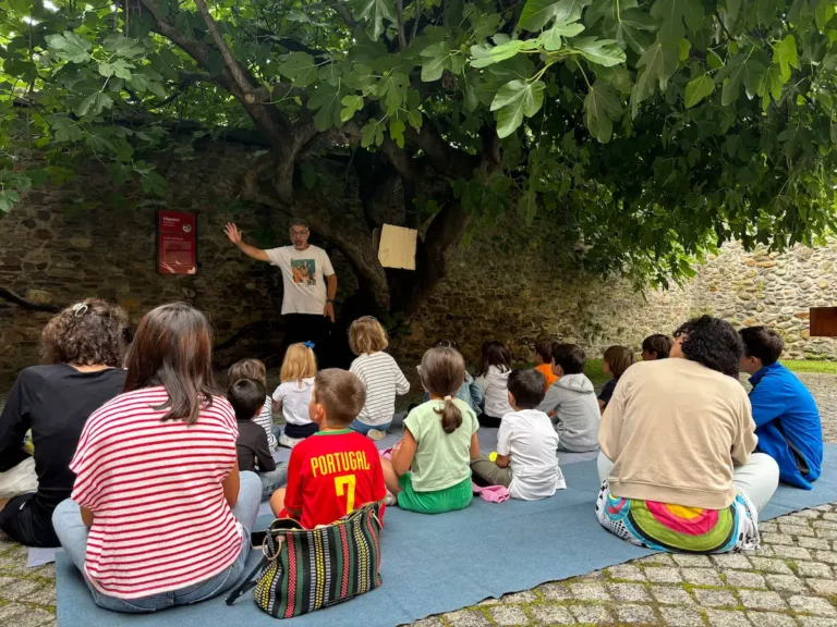 Niños y familias participan en una actividad de cuentacuentos bajo la higuera del patio del Museo del Bierzo.