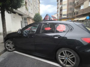 Vehículo de autoescuela con un cartel que reclama más examinadores de Tráfico para la provincia de León.