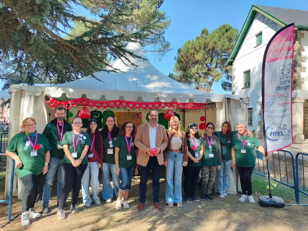 Equipo de CIMA Integra en 2025 y representantes municipales junto a la carpa del servicio durante la Ciudad Mágica de Ponferrada